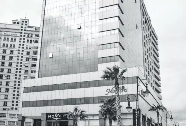 Grayscale Photo of City Buildings and Cars on Road